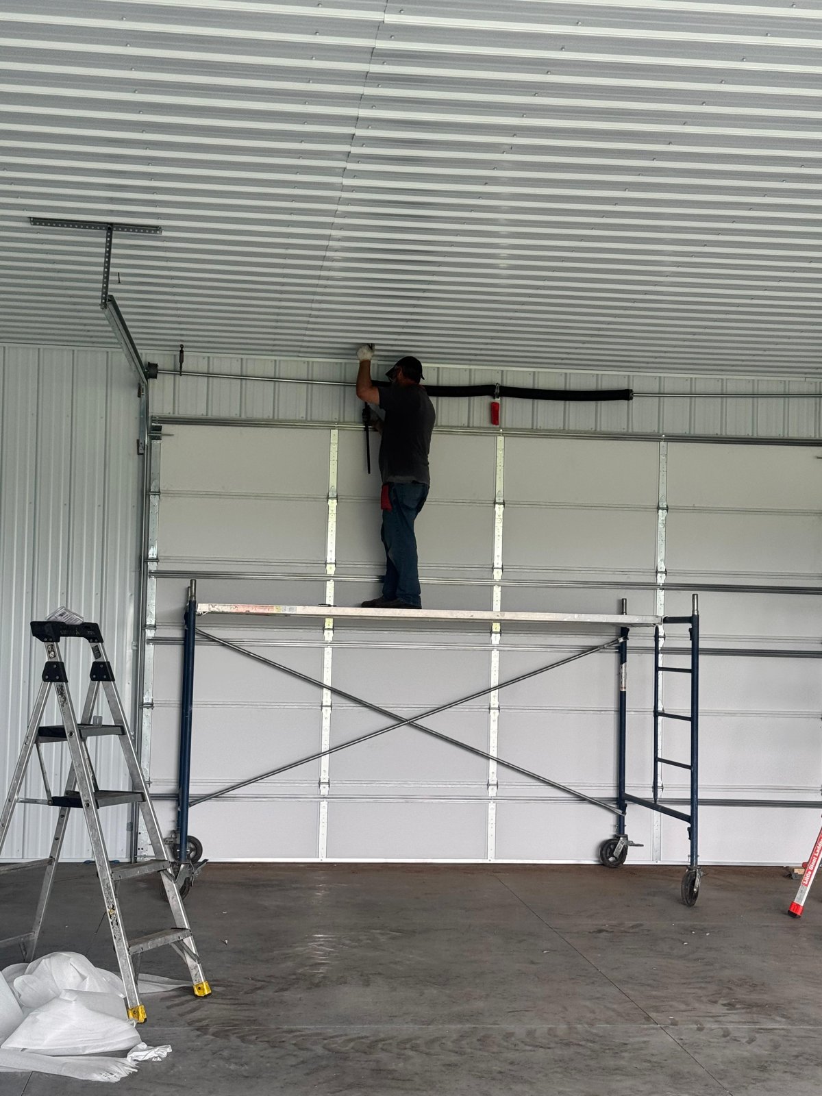 Installing a large garage door from a scaffold in a new pole building