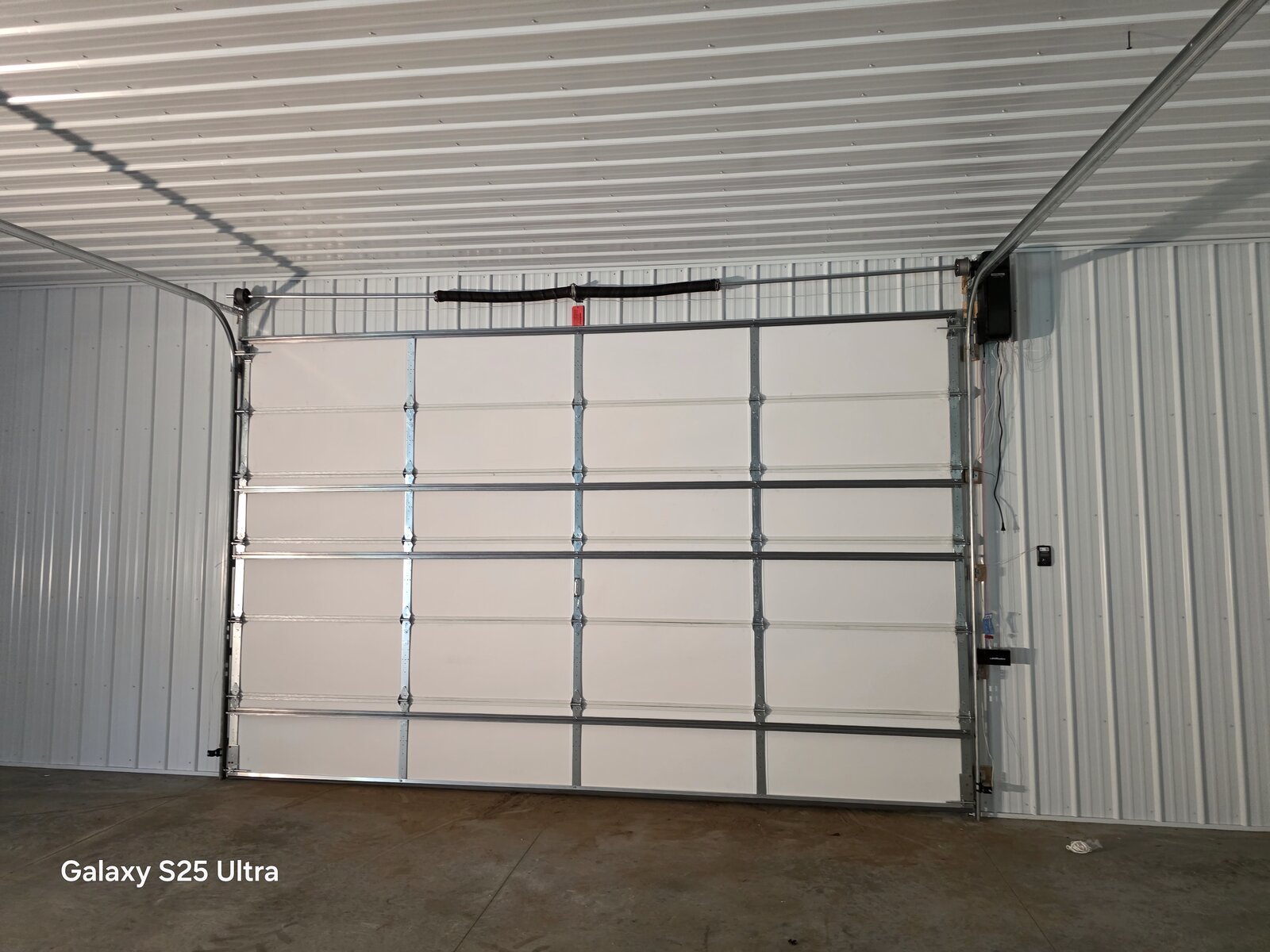 New garage door and opener installed in a steel building