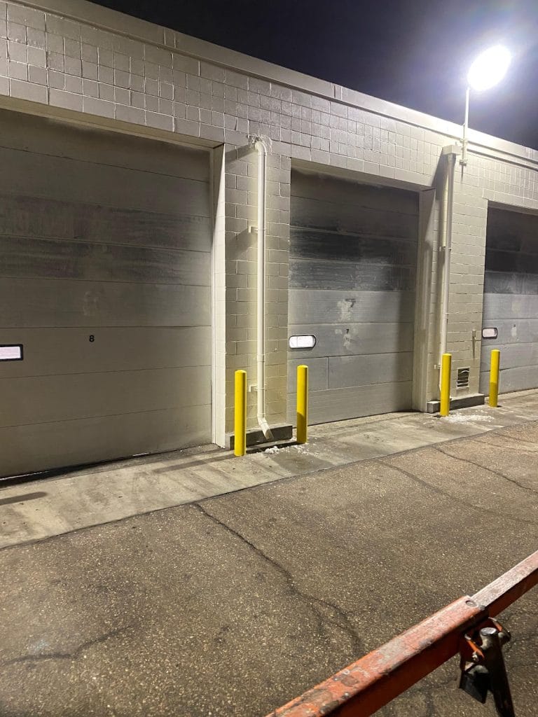 Commercial sectional steel doors at loading bays repaired at night, Twin Cities