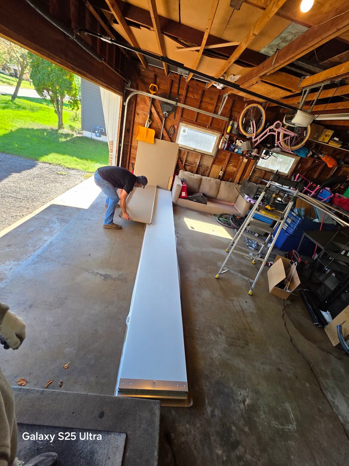 David carrying a 2-inch insulated DoorLink garage door section into a Twin Cities garage - factory insulation is bonded between two steel skins