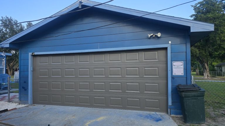 New grey garage door on a blue detached garage, serving New Hope, MN