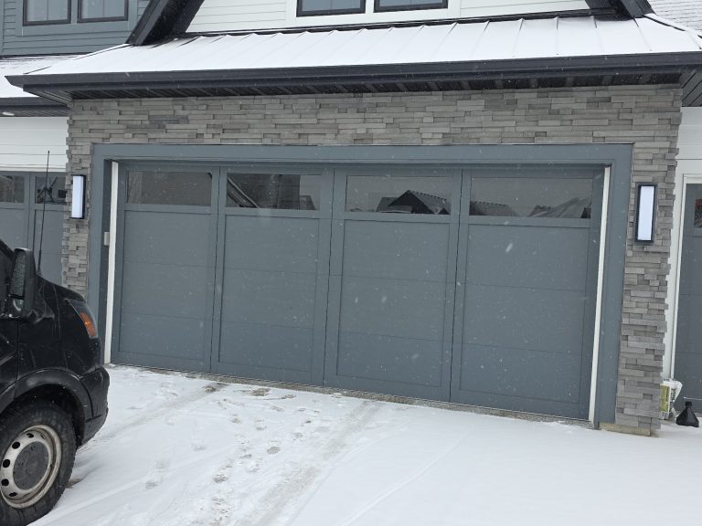 New grey garage door installed in the snow, Minnesota, serving Golden Valley, MN
