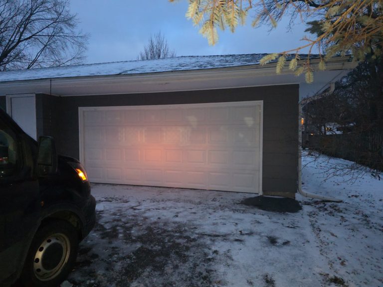 Modern dark garage door with lighting, evening exterior view