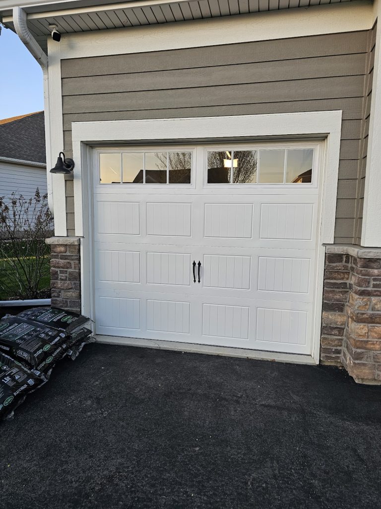 White carriage-style garage door with stone trim, serving South St. Paul, MN