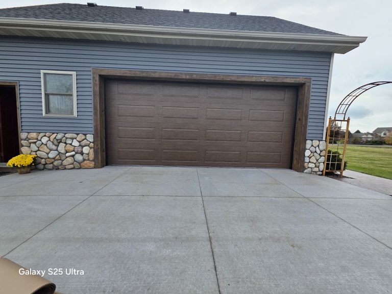 Wood-look garage door on a grey-sided home, serving Champlin, MN