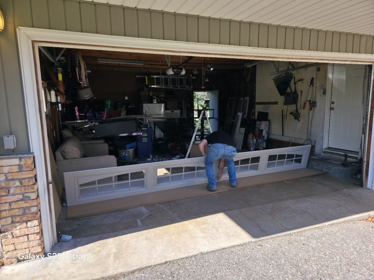 David assembling new garage door sections with window inserts on the driveway