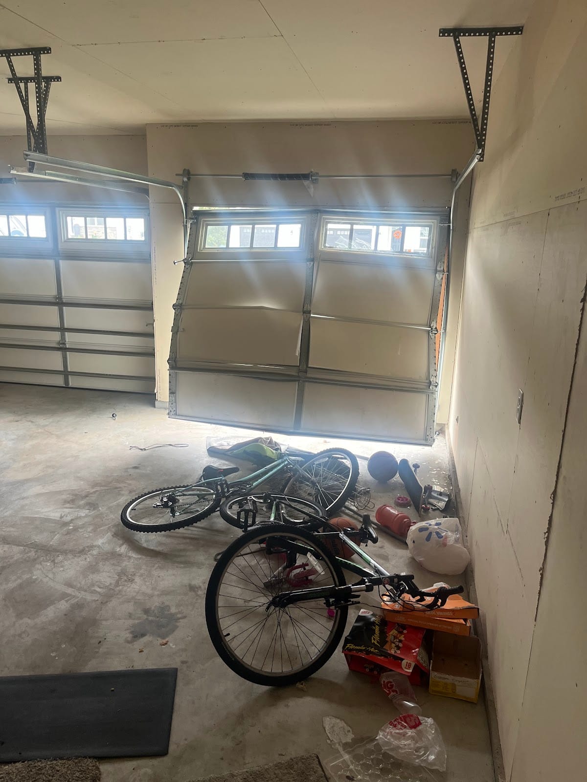 Bent and buckled garage door sections seen from inside the garage, before replacement
