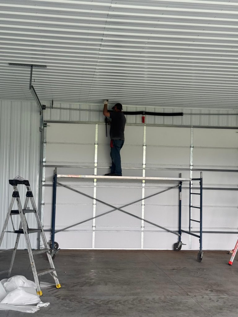 Commercial garage door installation on scaffolding, Minnesota