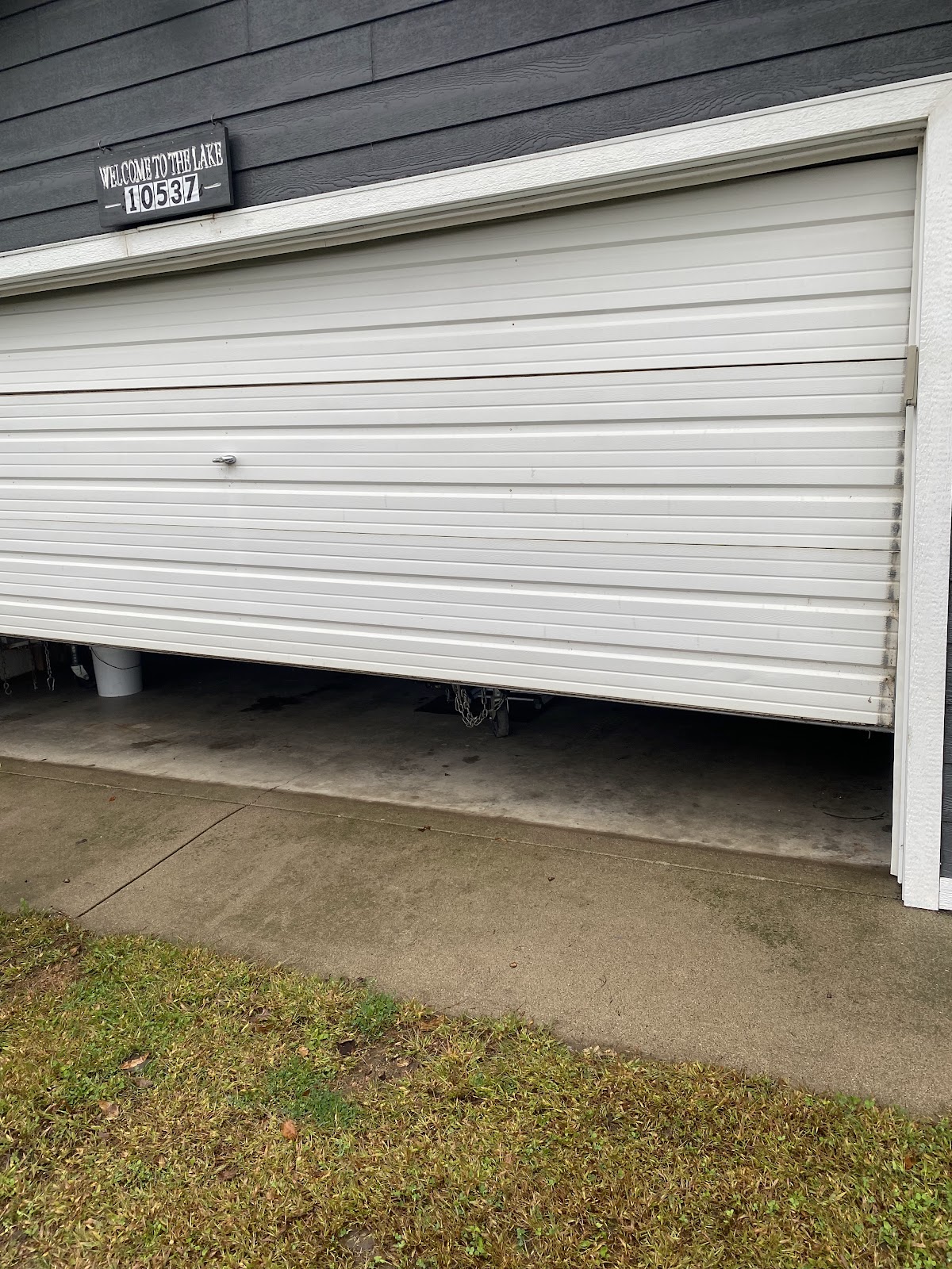 Garage door hanging crooked and off track on one side before repair