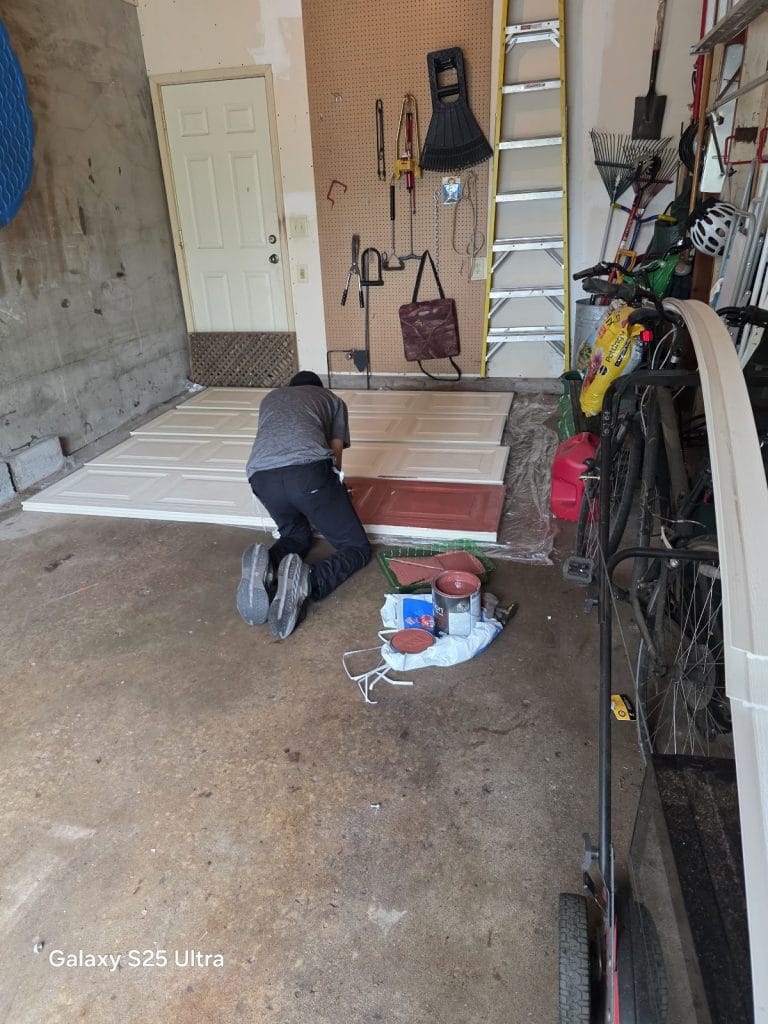 David laying out new garage door sections on the garage floor before installation, Minnesota