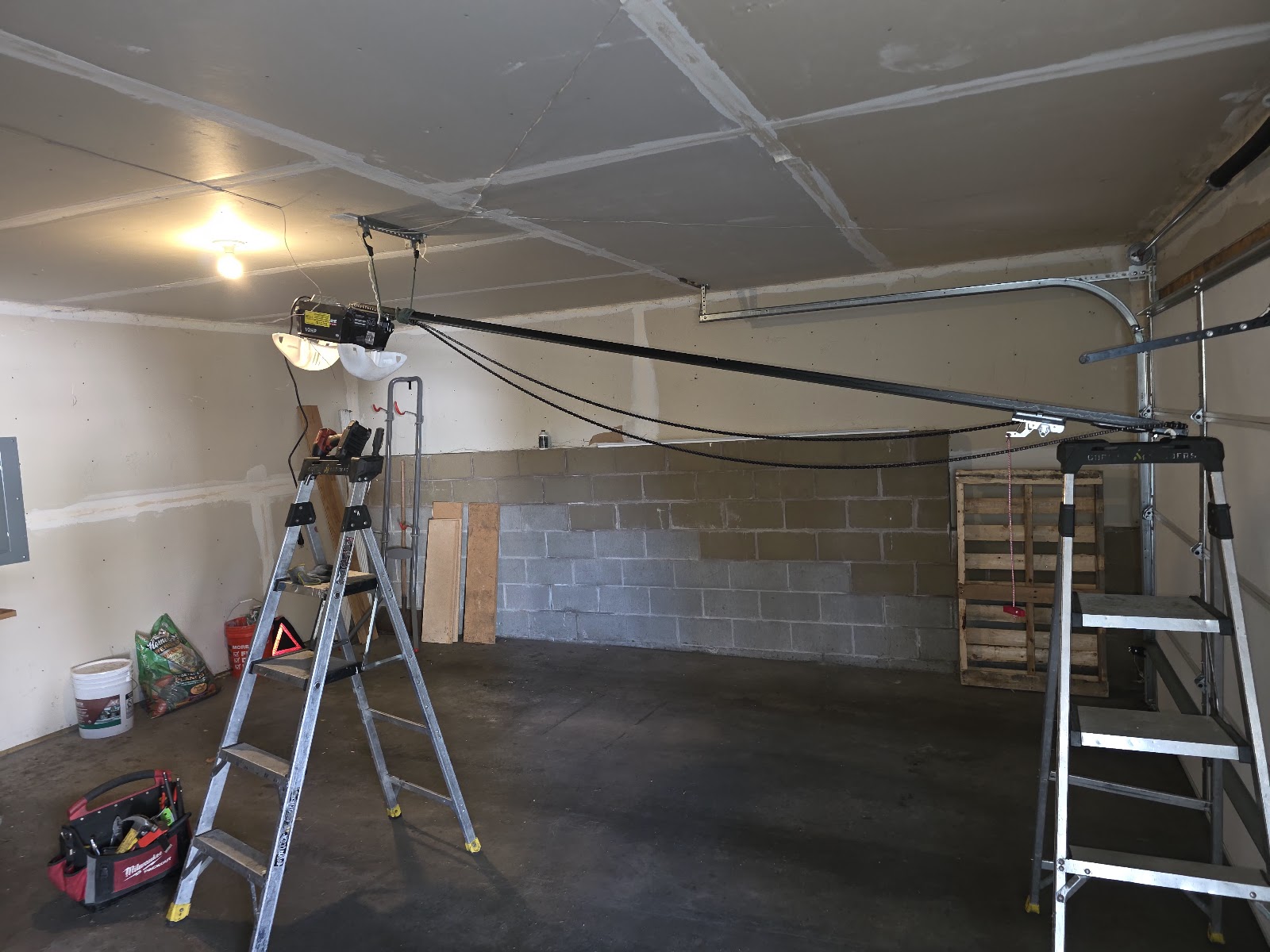 Opener rail going up in a block garage with the ladder set under it