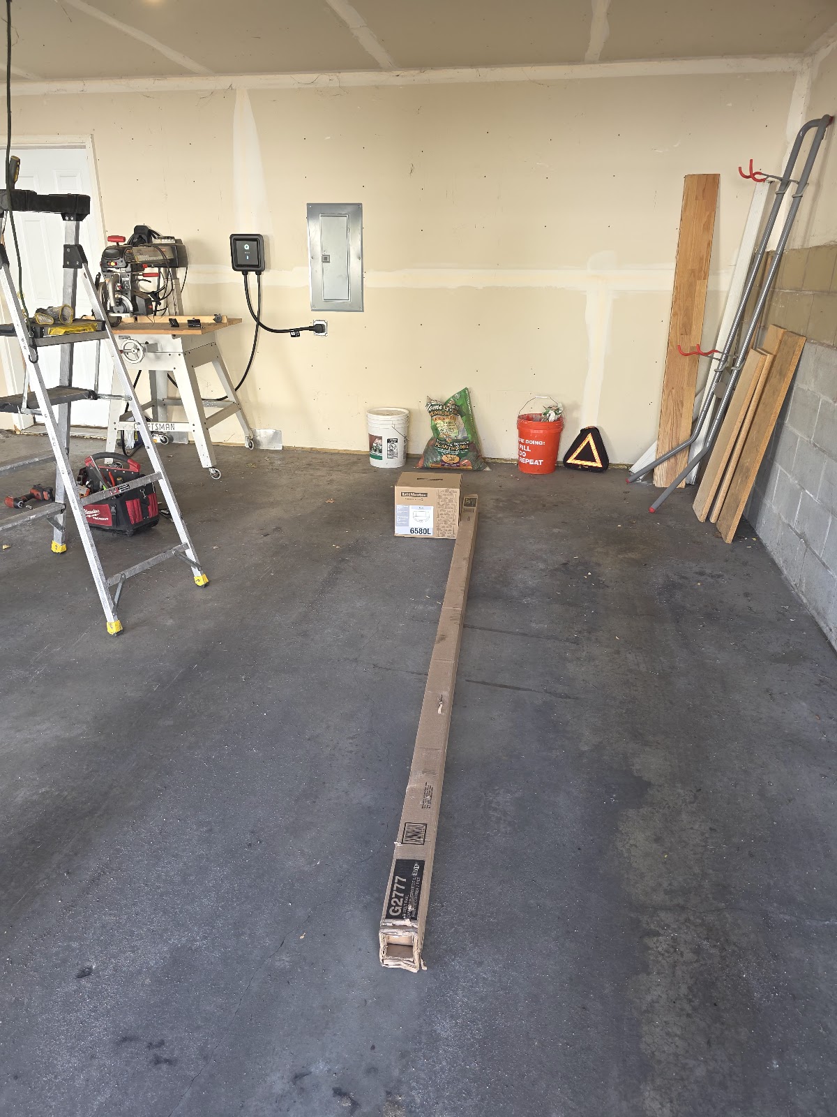 Vertical track and parts assembled on the floor for a new garage door install