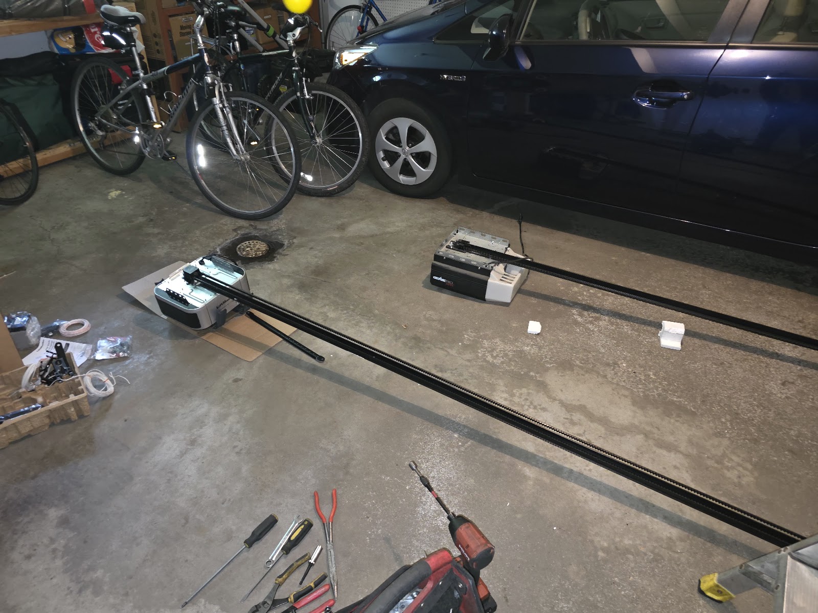 LiftMaster opener and rail laid out on the garage floor before installation