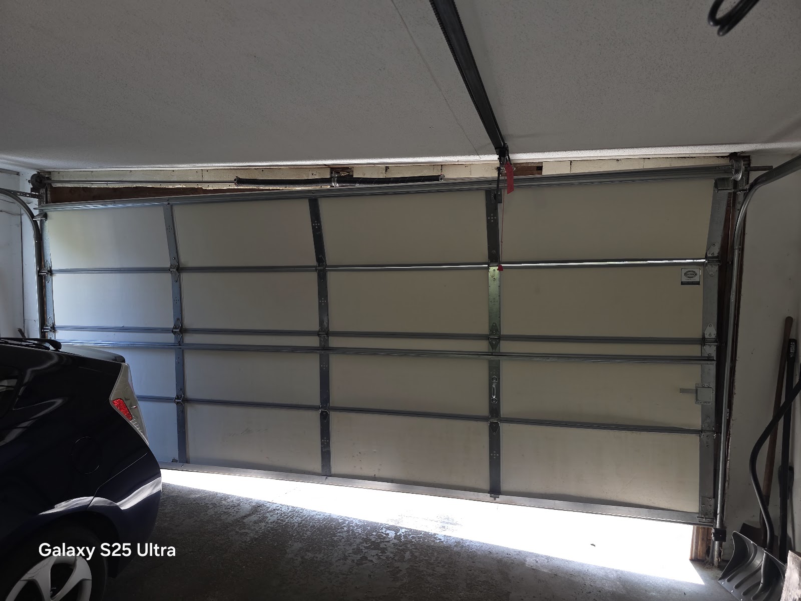 New garage door from inside showing struts and numbered hinges