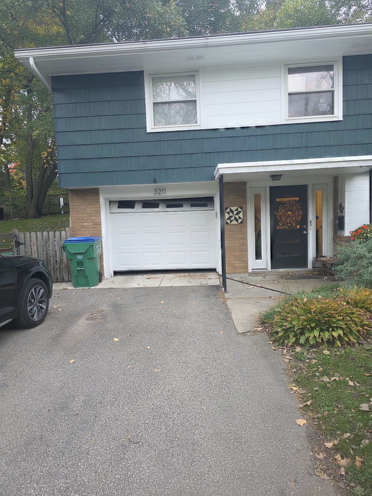 New white single garage door on a blue split-level home in Minnesota
