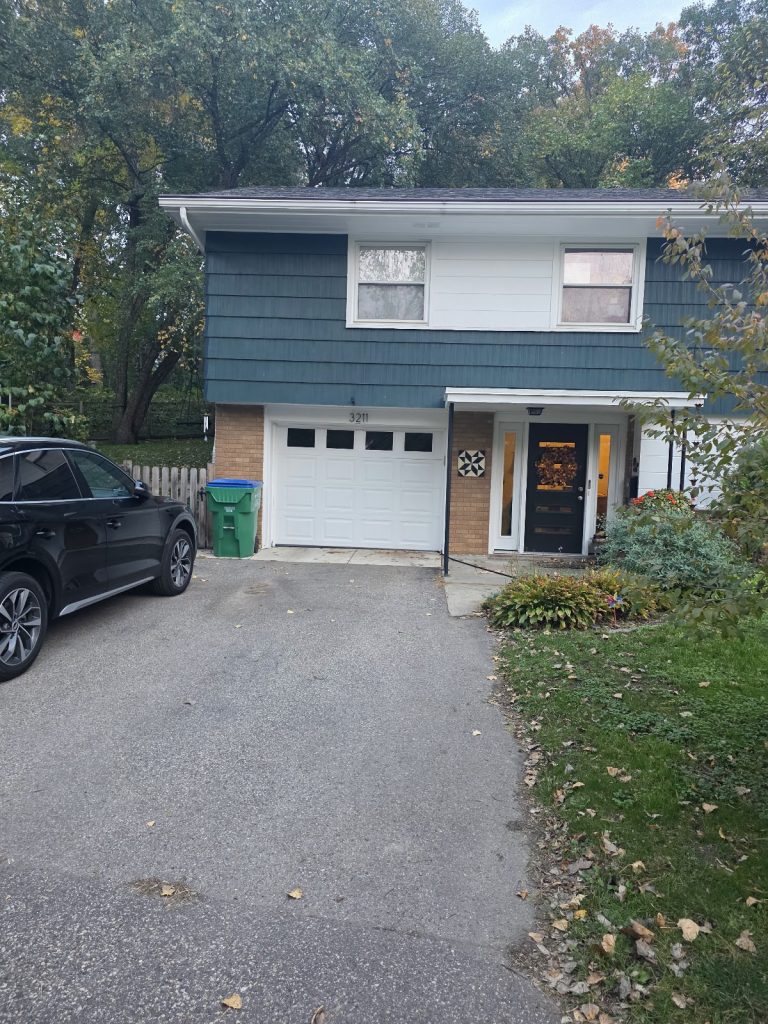 New white garage door installed on a blue-sided house in Minnesota