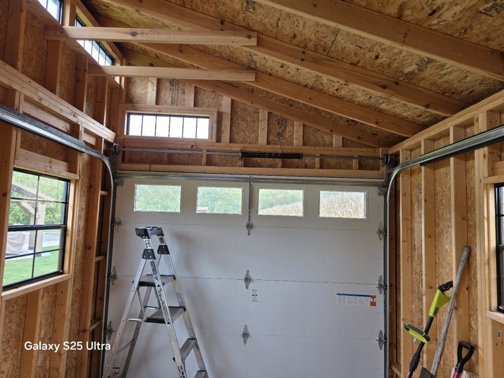 Newly installed white insulated garage door with a row of windows