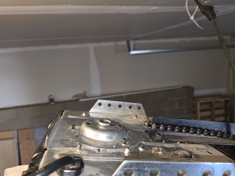 Torsion spring and shaft assembly above a garage door, close-up during repair