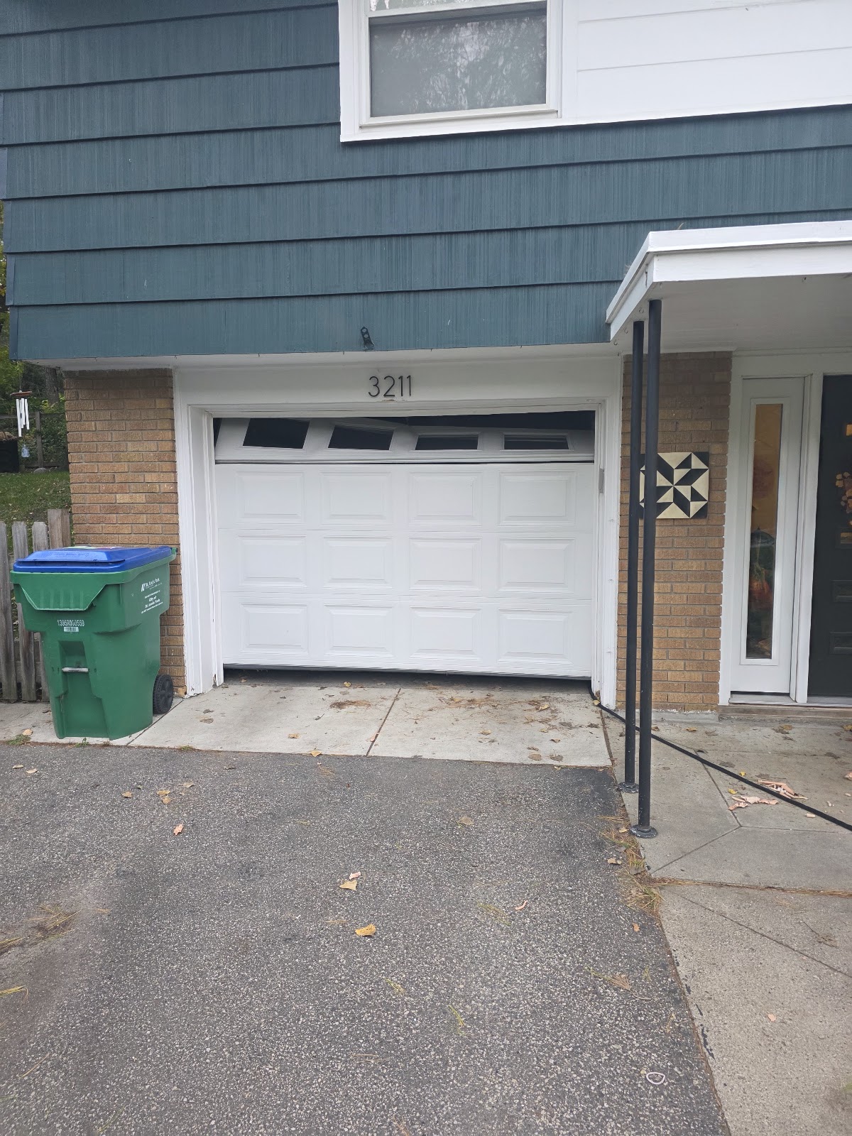 White raised-panel garage door with top windows on an attached garage