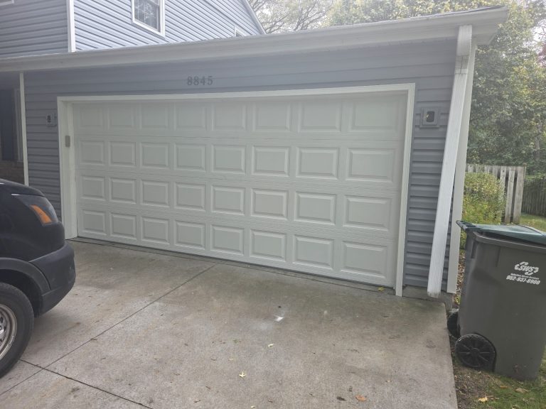 White steel raised-panel garage door after installation in Minnesota
